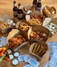 take out boxes with wings, fries, onion rings