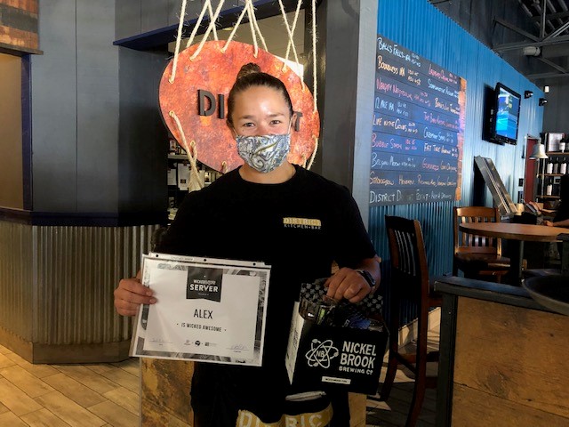 Winner Alex holding prize pack and wearing mask