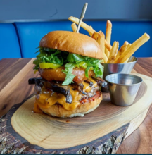 Burger and fries on wooden board